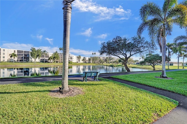 surrounding community featuring a water view and a lawn