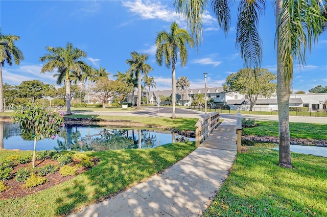 view of home's community featuring a lawn, a water view, and a residential view