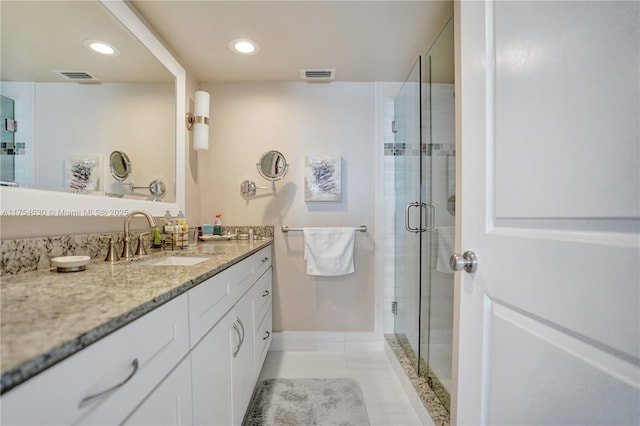 bathroom with a stall shower, vanity, and visible vents