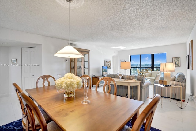 dining room with visible vents, a textured ceiling, and tile patterned floors