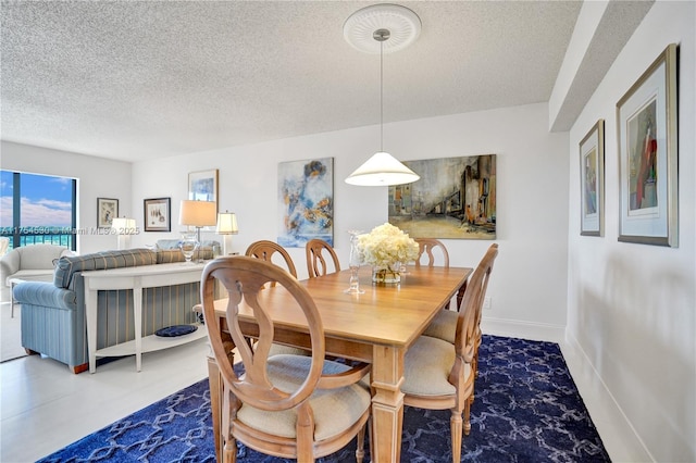 dining space with baseboards and a textured ceiling