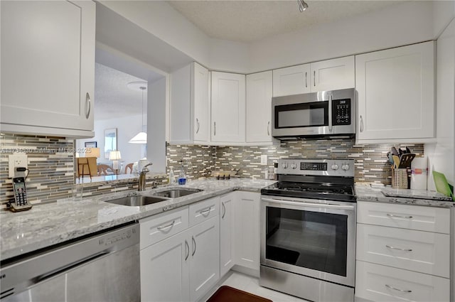 kitchen featuring stainless steel appliances, a sink, and decorative backsplash