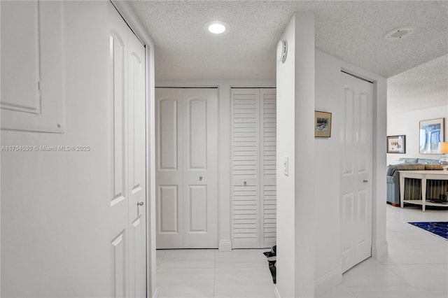 hall featuring a textured ceiling