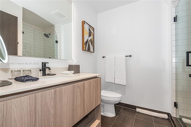 bathroom with visible vents, toilet, a stall shower, vanity, and tile patterned floors