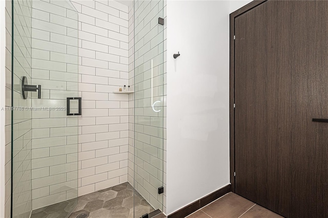 bathroom with a shower stall and baseboards