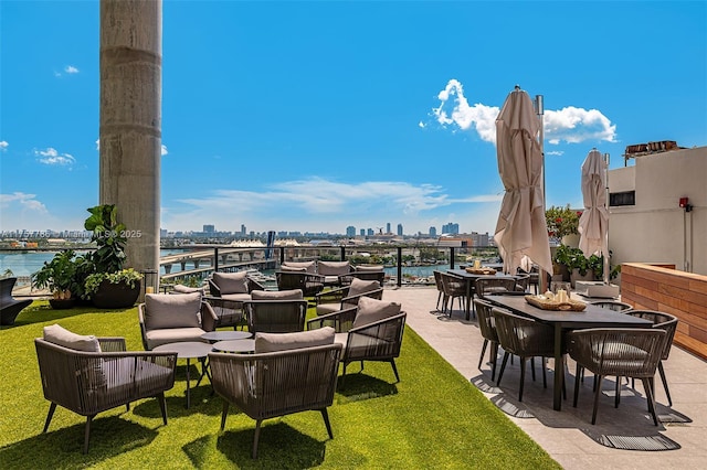 view of patio featuring a view of city, a water view, and an outdoor living space