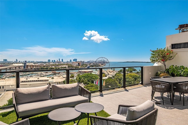 view of patio with a view of city, a water view, and a balcony