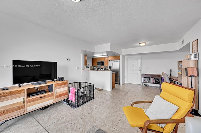 living area featuring visible vents, light tile patterned flooring, and a textured ceiling