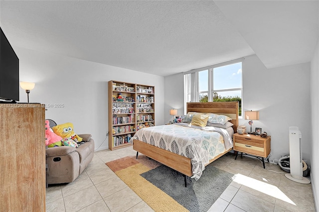 bedroom with light tile patterned floors and a textured ceiling