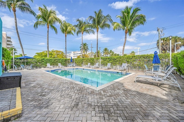 pool with a patio area and fence