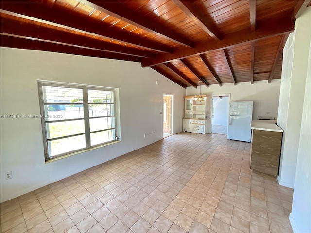 unfurnished living room with wooden ceiling, light tile patterned flooring, a notable chandelier, and lofted ceiling with beams