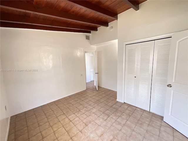 unfurnished bedroom featuring a closet, wooden ceiling, visible vents, and lofted ceiling with beams