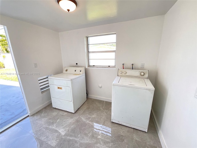 laundry area with laundry area, washing machine and clothes dryer, and baseboards