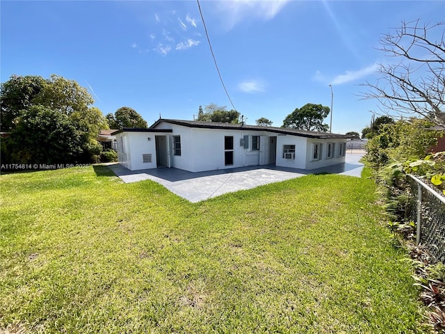 back of property featuring stucco siding, a lawn, fence, and a patio