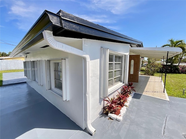 view of home's exterior with fence and stucco siding