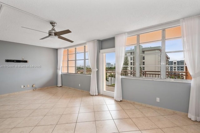 tiled empty room featuring a textured ceiling, ceiling fan, and a city view