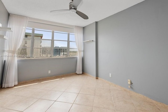 tiled empty room featuring ceiling fan