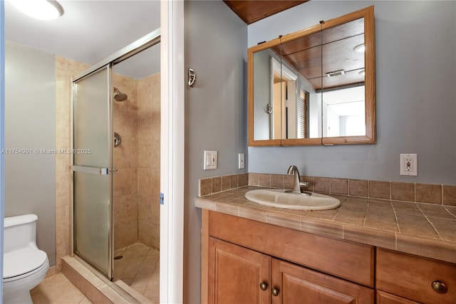 bathroom with a shower stall, toilet, and vanity