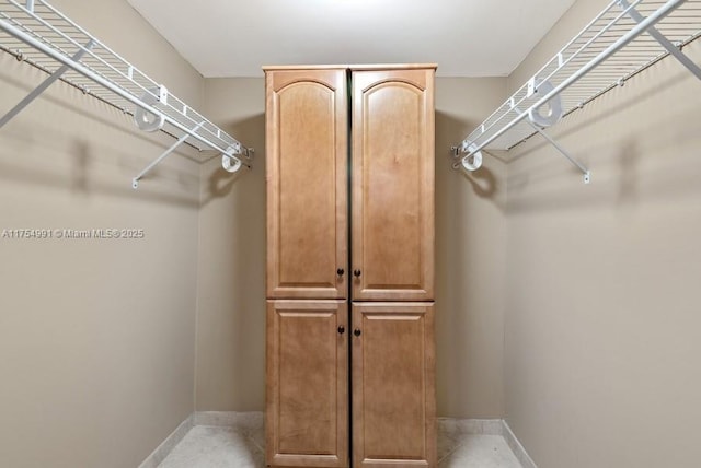 spacious closet with light tile patterned floors