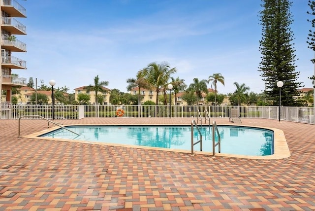 community pool featuring a patio area and fence