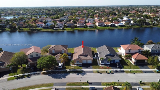 drone / aerial view with a water view and a residential view