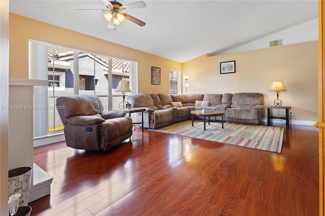 living room featuring lofted ceiling, visible vents, a textured ceiling, and wood finished floors