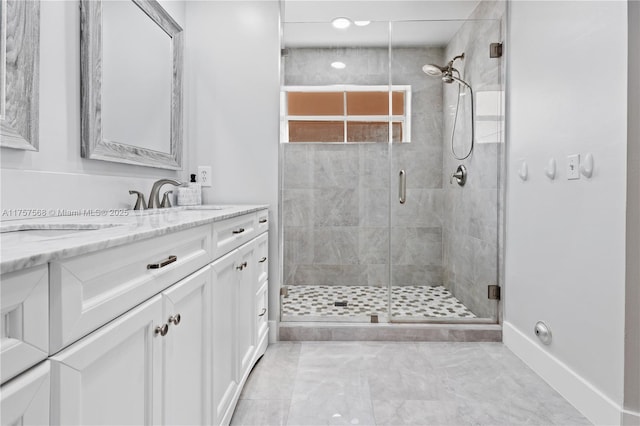 bathroom featuring baseboards, a shower stall, and vanity