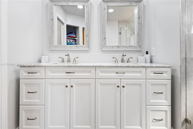 bathroom with double vanity, a shower, and a sink