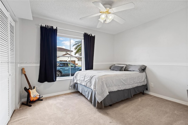 bedroom featuring carpet, baseboards, ceiling fan, and a textured ceiling