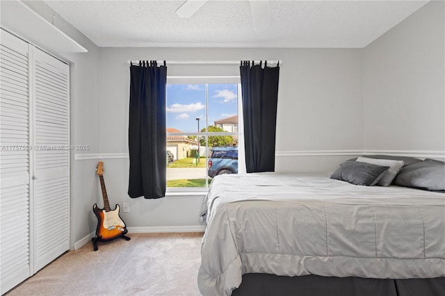 bedroom with carpet floors, ceiling fan, baseboards, and a textured ceiling