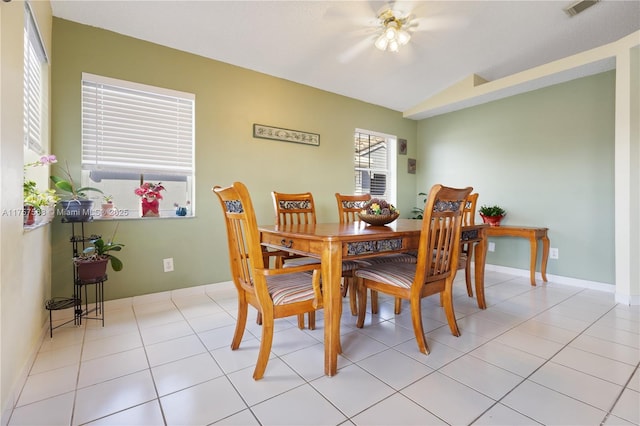 dining room featuring visible vents, vaulted ceiling, baseboards, and light tile patterned floors