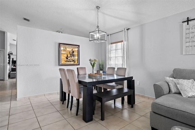 dining area with light tile patterned floors, baseboards, visible vents, a textured ceiling, and a chandelier