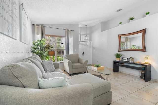 living area with visible vents, vaulted ceiling, a textured ceiling, and light tile patterned floors