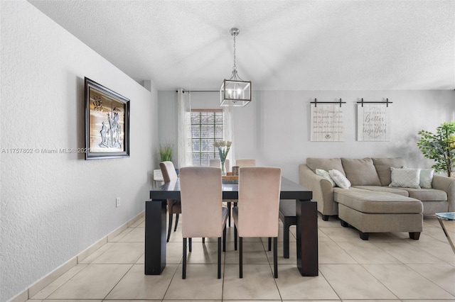 dining space with baseboards, a textured wall, a textured ceiling, a chandelier, and light tile patterned flooring