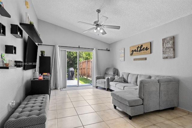 living room with light tile patterned floors, ceiling fan, vaulted ceiling, and a textured ceiling