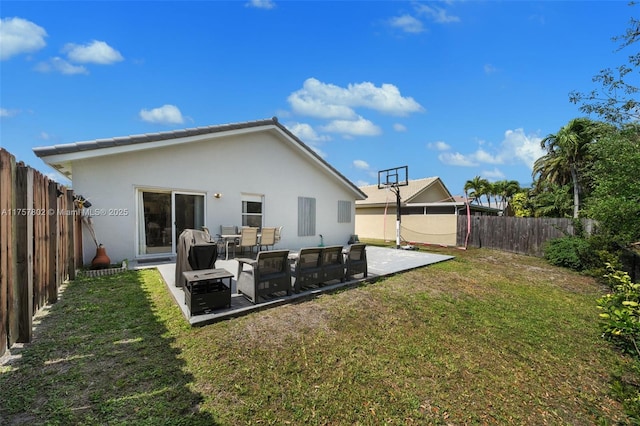 rear view of house with a fenced backyard, a patio, a lawn, and stucco siding