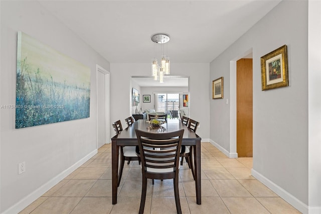 dining area featuring a notable chandelier, light tile patterned flooring, and baseboards