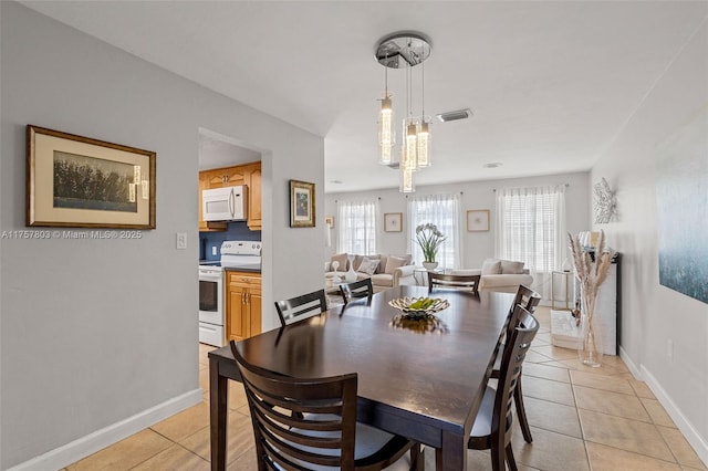 dining room featuring light tile patterned floors, baseboards, and visible vents