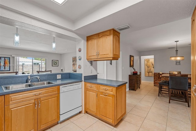 kitchen featuring dark countertops, white dishwasher, a sink, and light tile patterned flooring