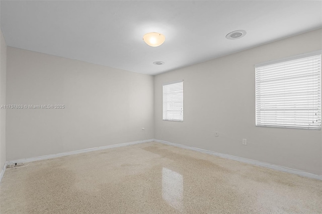 spare room with speckled floor and baseboards