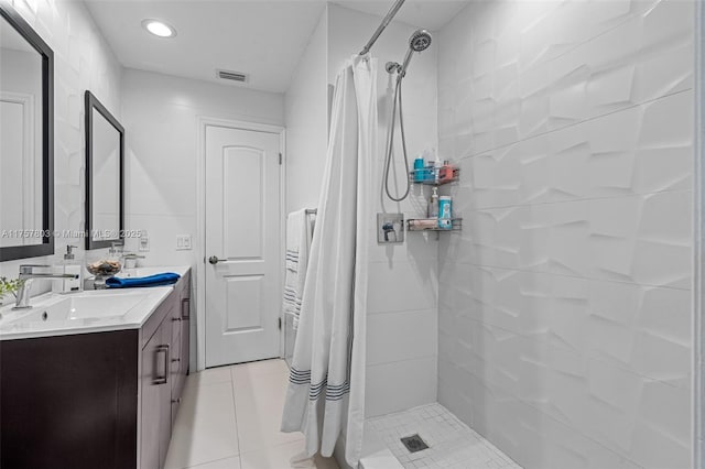 bathroom featuring double vanity, visible vents, a stall shower, a sink, and tile patterned floors