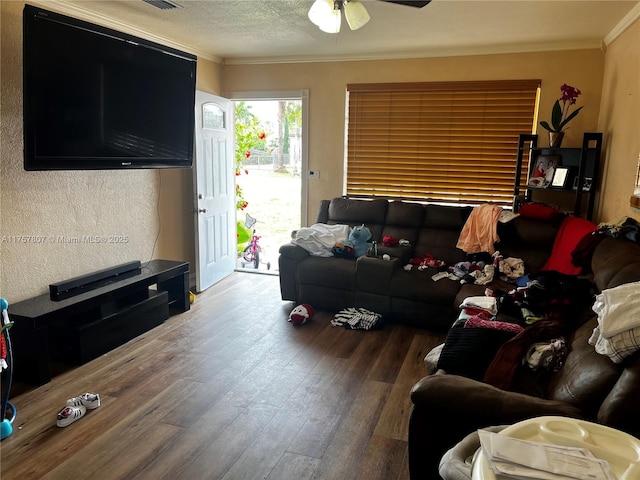 living room featuring visible vents, ceiling fan, ornamental molding, wood finished floors, and a textured ceiling