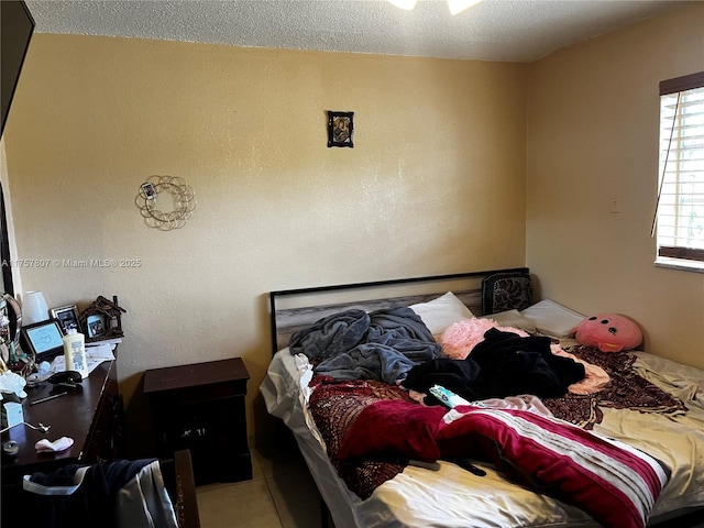 bedroom with a textured ceiling and tile patterned flooring