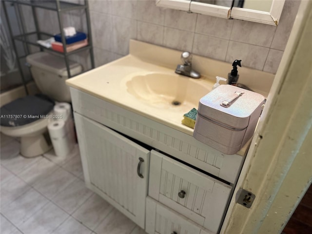 bathroom featuring tile walls, toilet, tile patterned floors, vanity, and backsplash