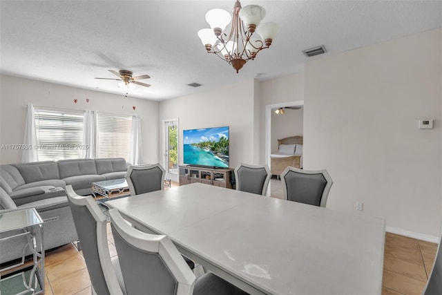 dining space with ceiling fan with notable chandelier, visible vents, and light tile patterned flooring