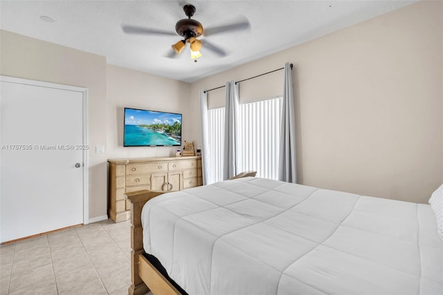 bedroom featuring a ceiling fan, baseboards, and light tile patterned floors