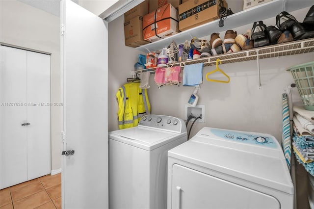 laundry area with washer and dryer, laundry area, and light tile patterned flooring