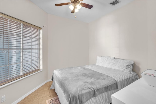 bedroom featuring a ceiling fan, visible vents, baseboards, and light tile patterned floors