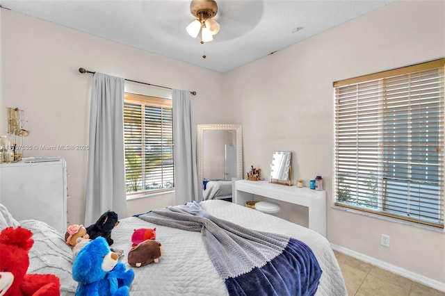 tiled bedroom featuring ceiling fan and baseboards