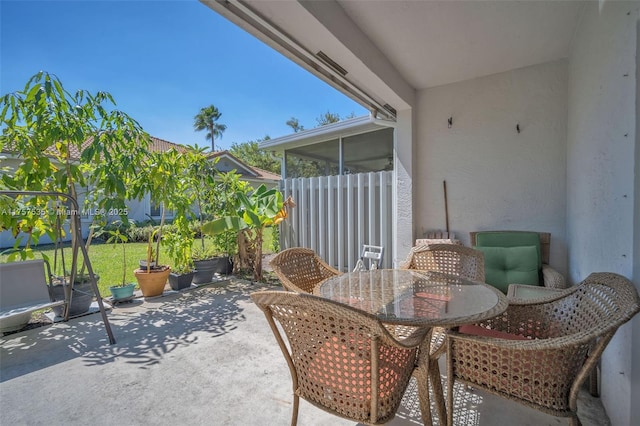 view of patio / terrace with a sunroom and outdoor dining area